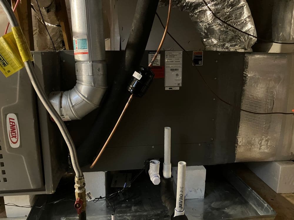 Lennox heating unit with copper piping and ventilation in a basement setting.