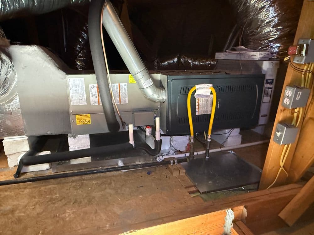 HVAC unit in a residential attic, showcasing insulation and ductwork details.