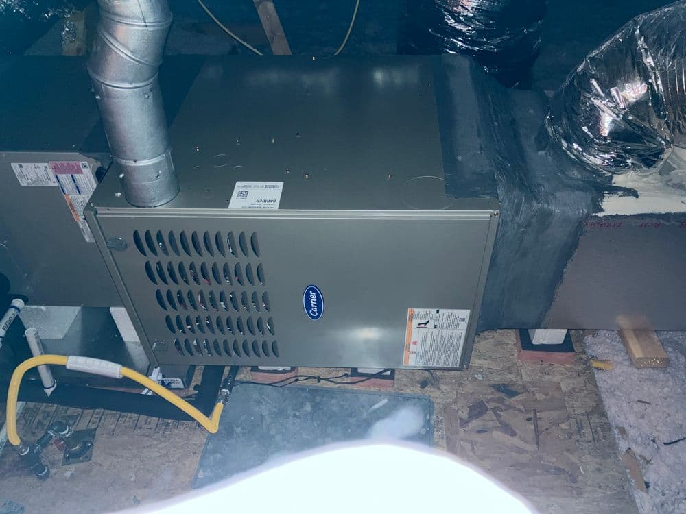 Furnace installation in attic with ductwork and ventilation system.