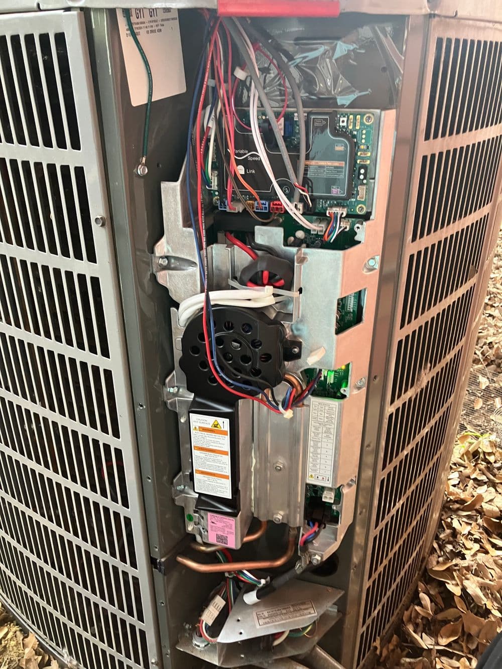 Inside view of an air conditioning unit showing wiring and components for maintenance inspection.